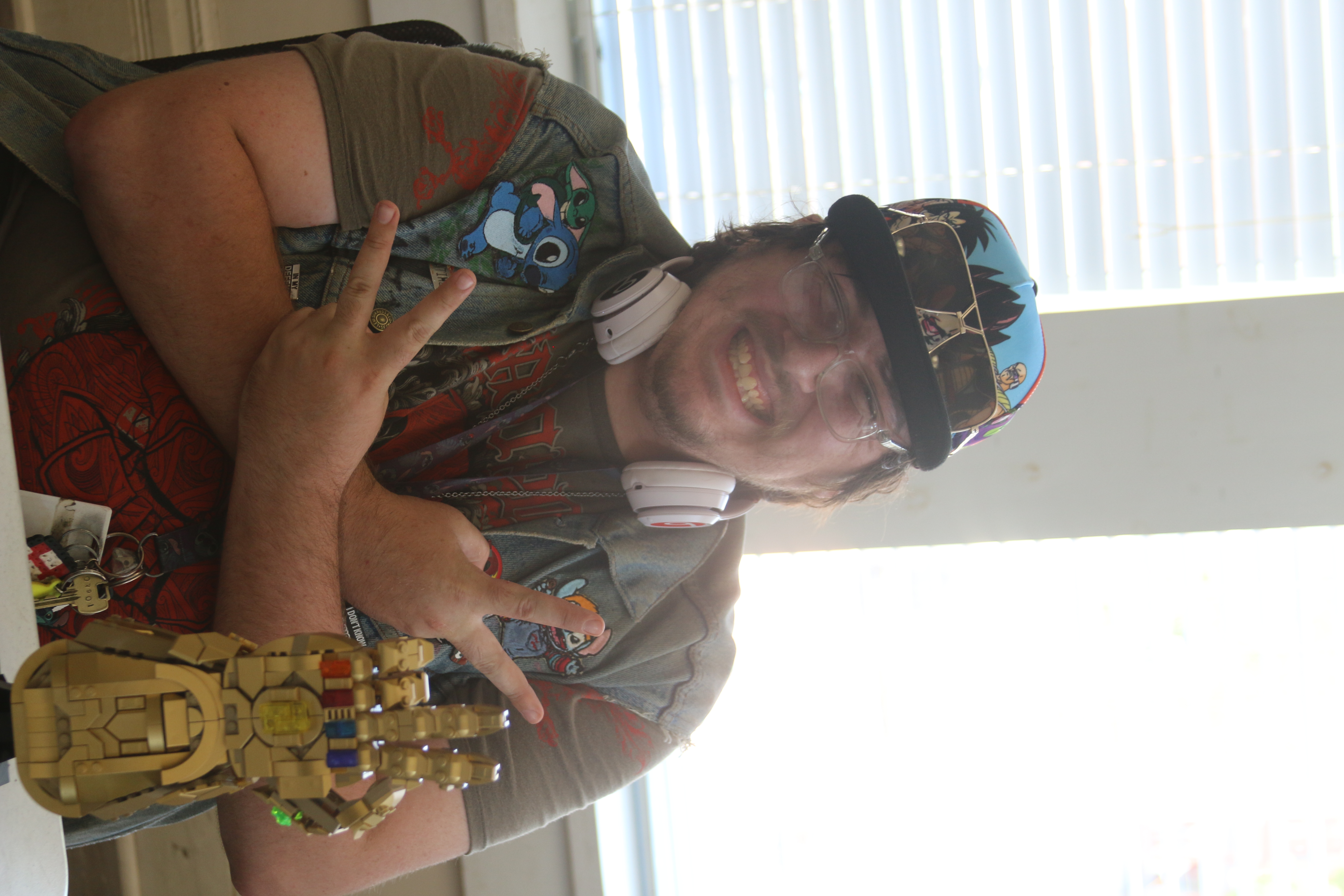 photo of person smiling at camera and holding up two peace signs.